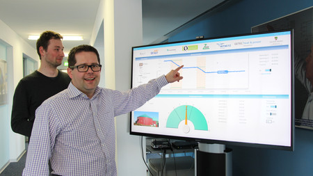 Das Foto zeigt Dr.-Ing. Przemyslaw Komarnicki bei der Erläuterung einer Grafik.