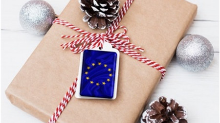 Das Bild zeigt ein verpacktes Weihnachtsgeschenk mit dem EU-Logo am Schleifenband..