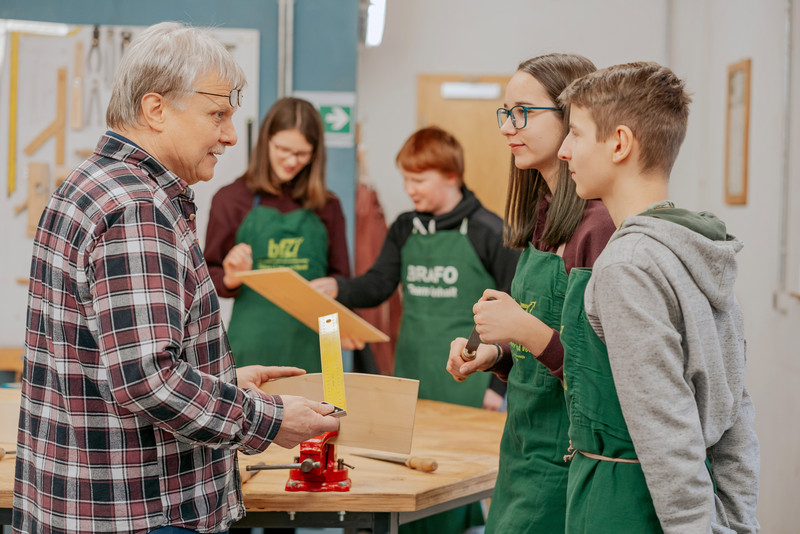 Das Bild zeigt Schülerinnen und Schüler, denen ein Handwerksberuf erklärt wird. 