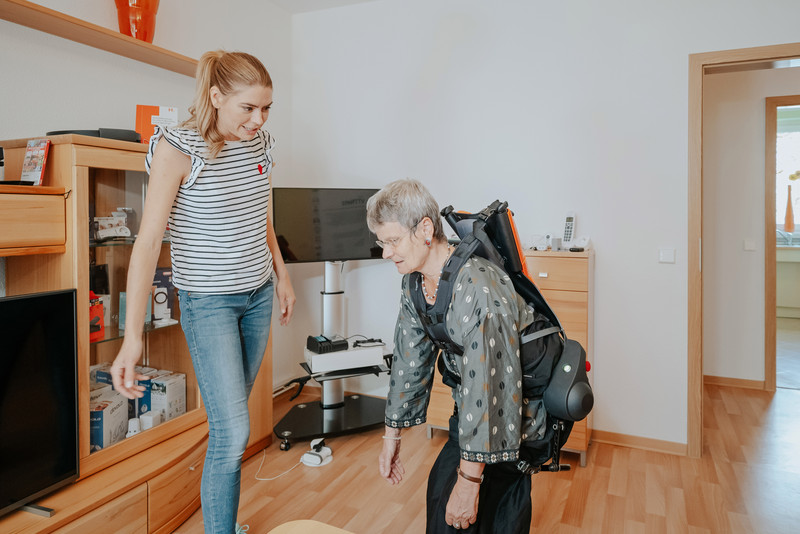 Das Foto zeigt zwei Frauen, von denen eine ein Exoskelett trägt. 
