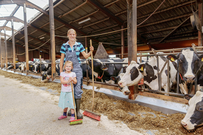 Das Bild zeigt Junglandwirtin Andrea Finke mit ihrer Tochter im Kuhstall.