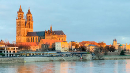 Das Foto zeigt den Magdeburger Dom mit der Elbe davor.